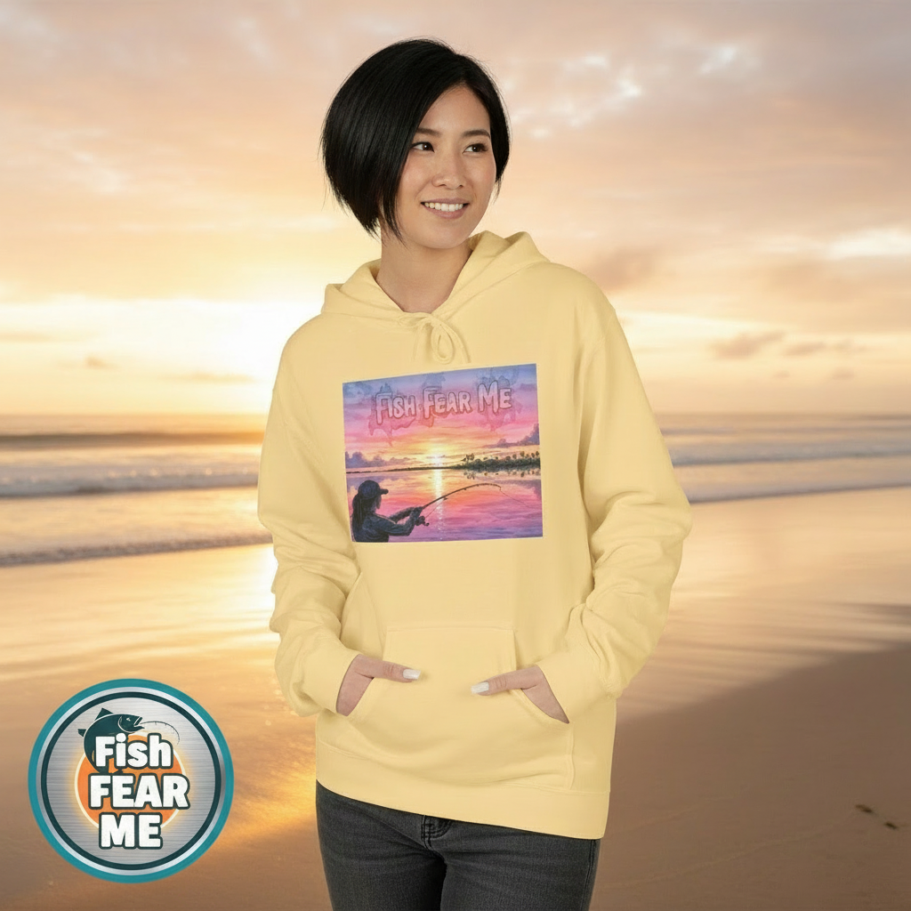 Person wearing a yellow hoodie with a graphic design, standing against a blurred natural background.