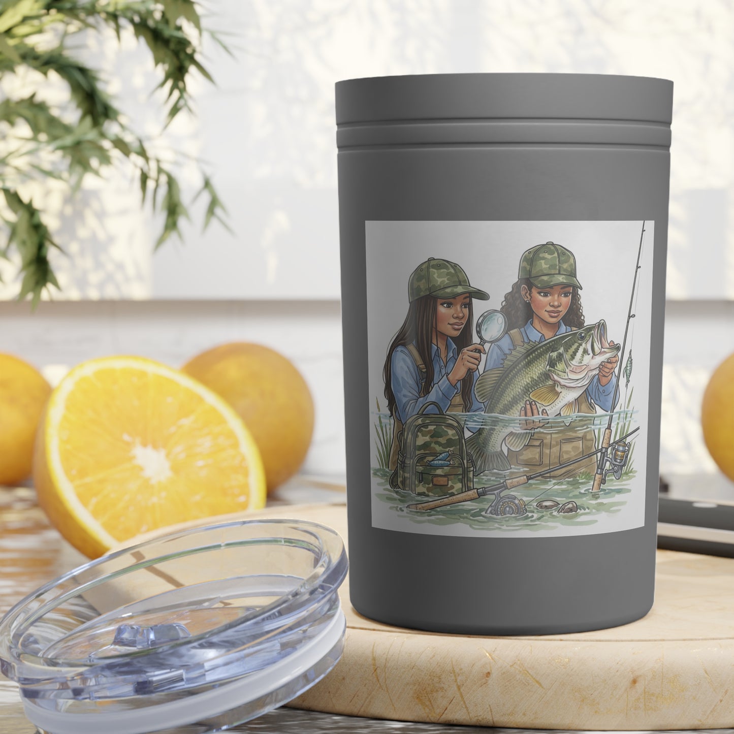 Gray tumbler with a design of two women fishing, surrounded by oranges and a plant.