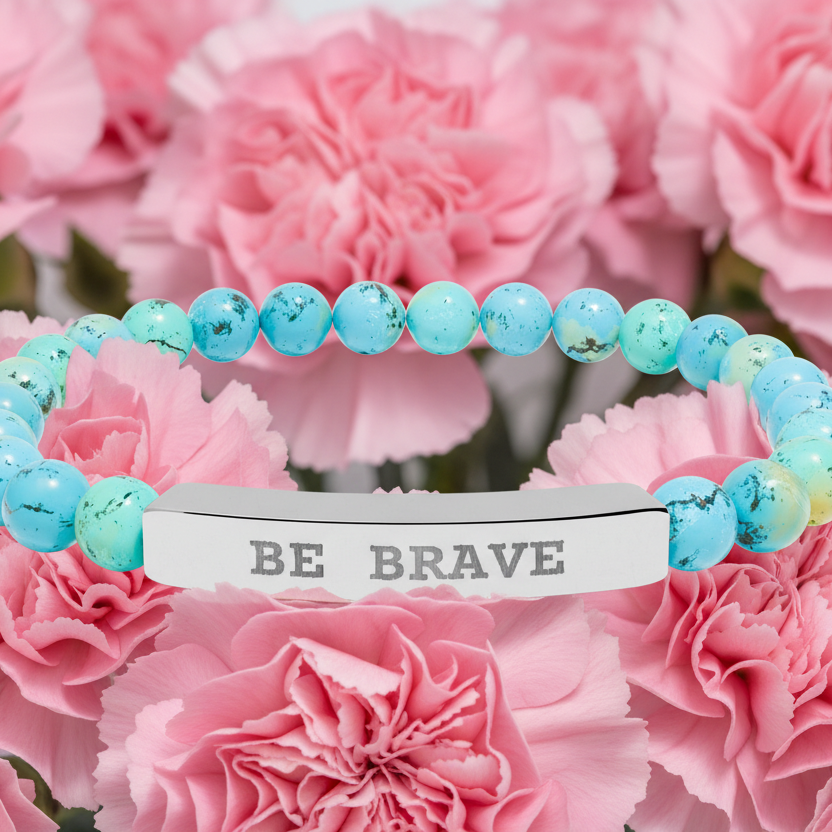 Turquoise natural stone beaded stretch bracelet with 'BE BRAVE' tag on pink flowers