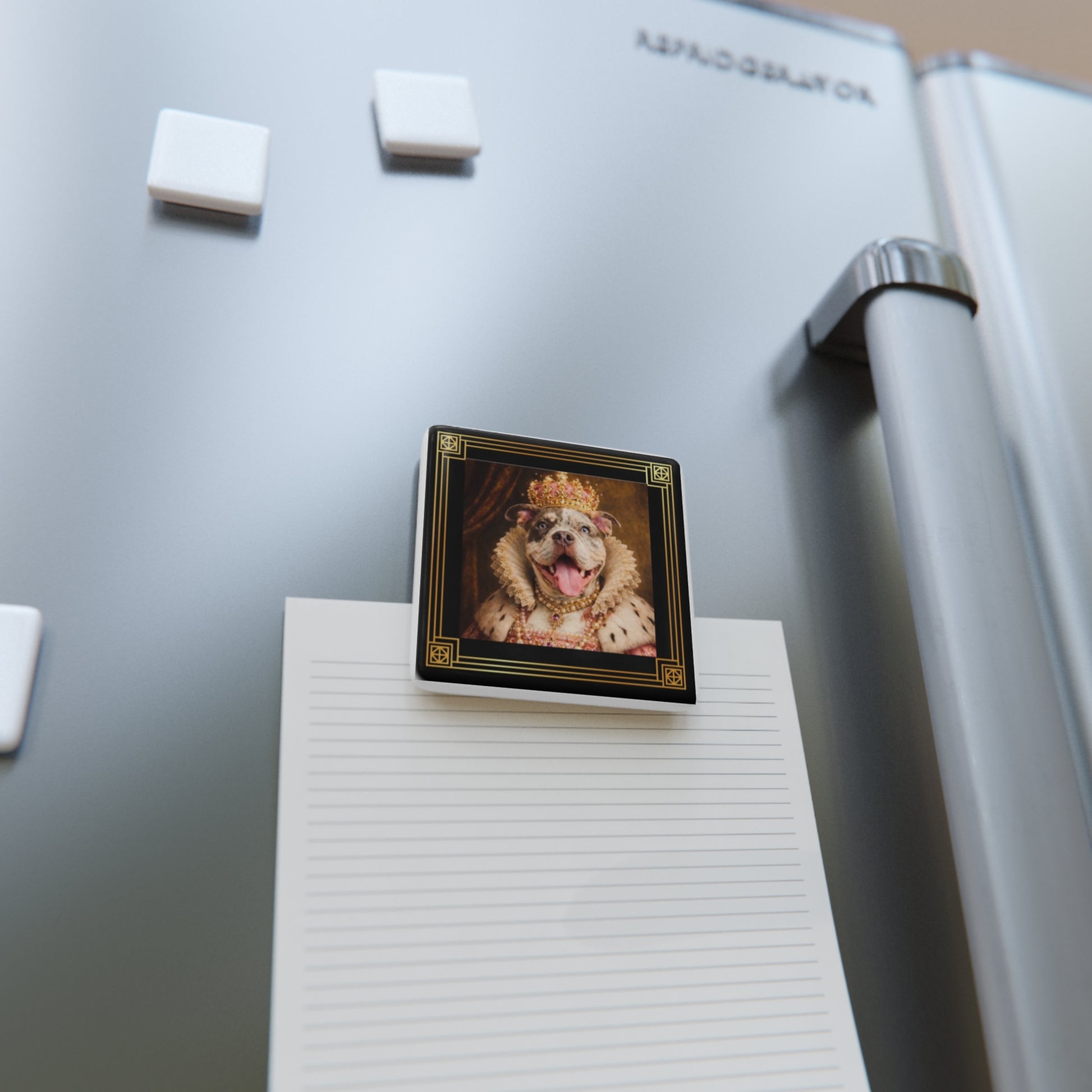 Fridge magnet with a Queen June's face on a refrigerator next to a notepad