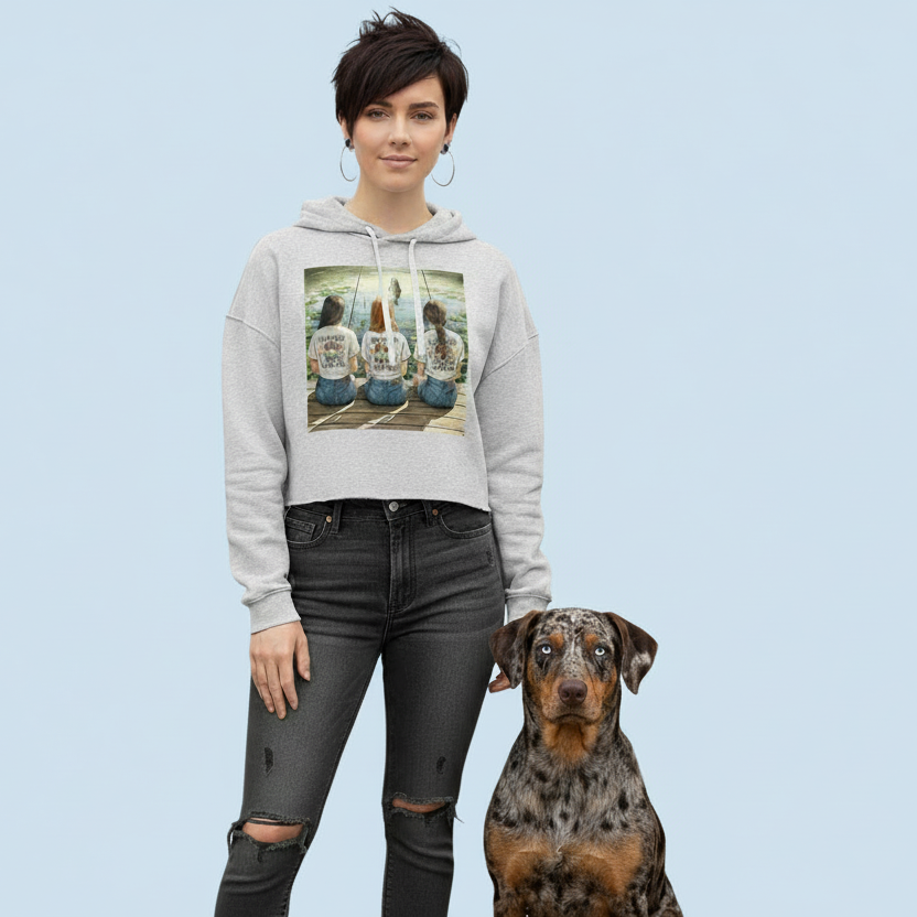 Woman wearing a white crop top hoodie with a catahoula leopard dog on a light blue background