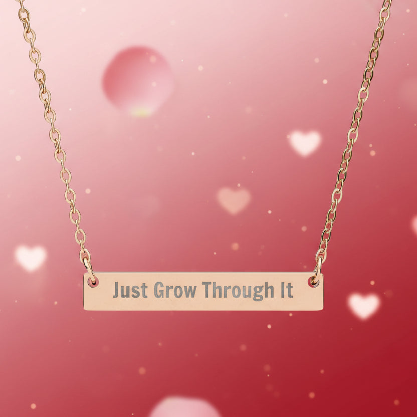 Necklace with 'Just Grow Through It' pendant on a pink background with heart shapes