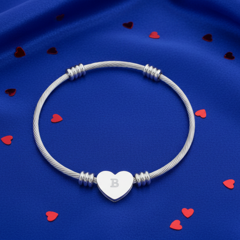 Silver bracelet with a heart-shaped charm on a blue background with red heart-shaped decorations.