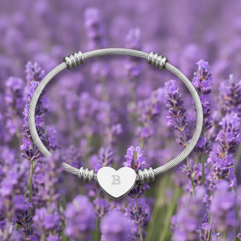Silver bracelet with a heart-shaped charm featuring the letter 'B' against a background of purple lavender flowers.