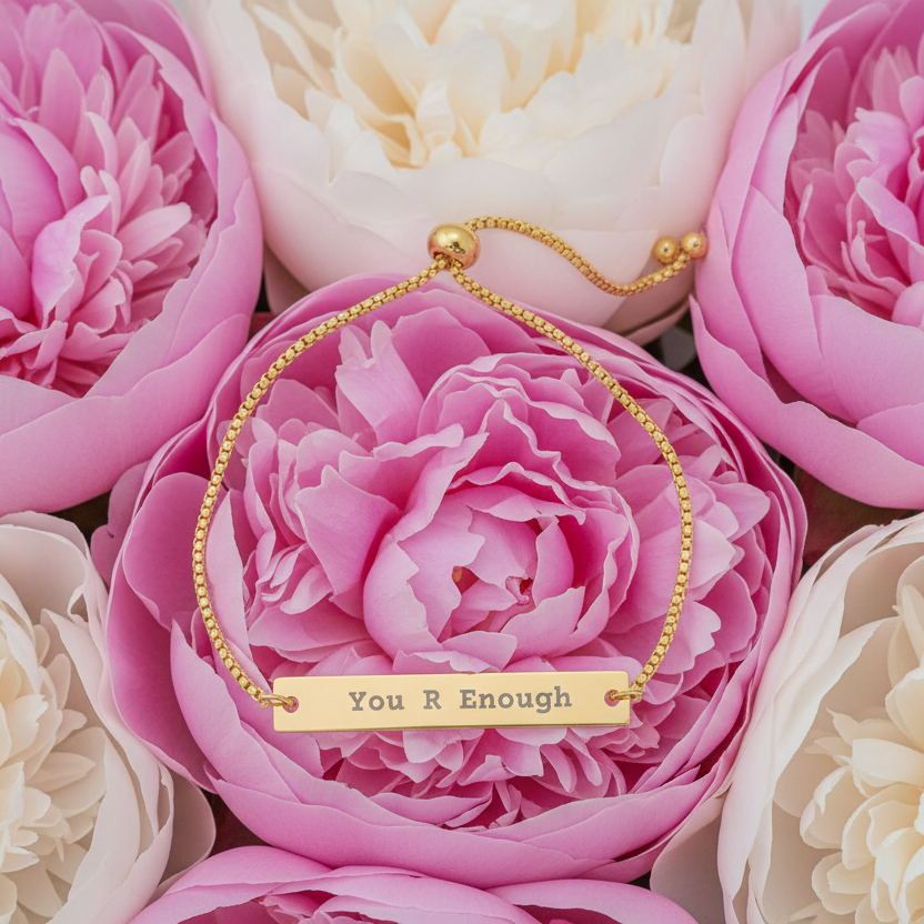 Gold bracelet with 'You R Enough' message on pink and white flowers