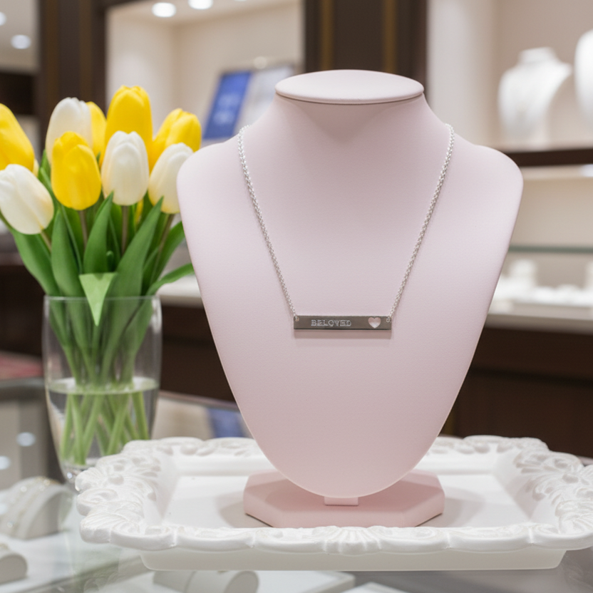 Beloved Necklace on a pink bust with yellow and white tulips in the background