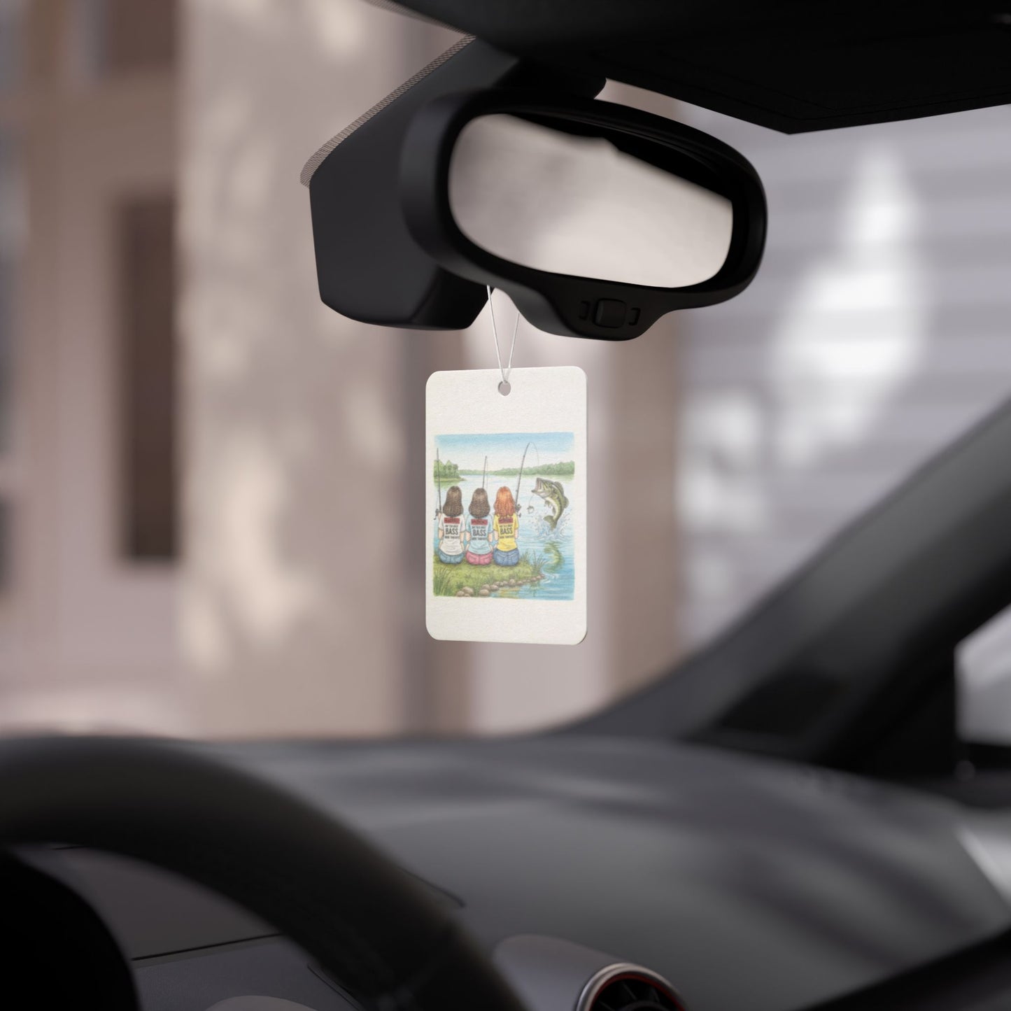 Car air freshener hanging from a car's rearview mirror with a scenic design.