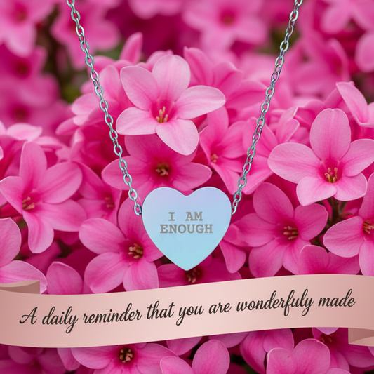 Necklace with a heart-shaped pendant on pink flowers with an inspirational quote.