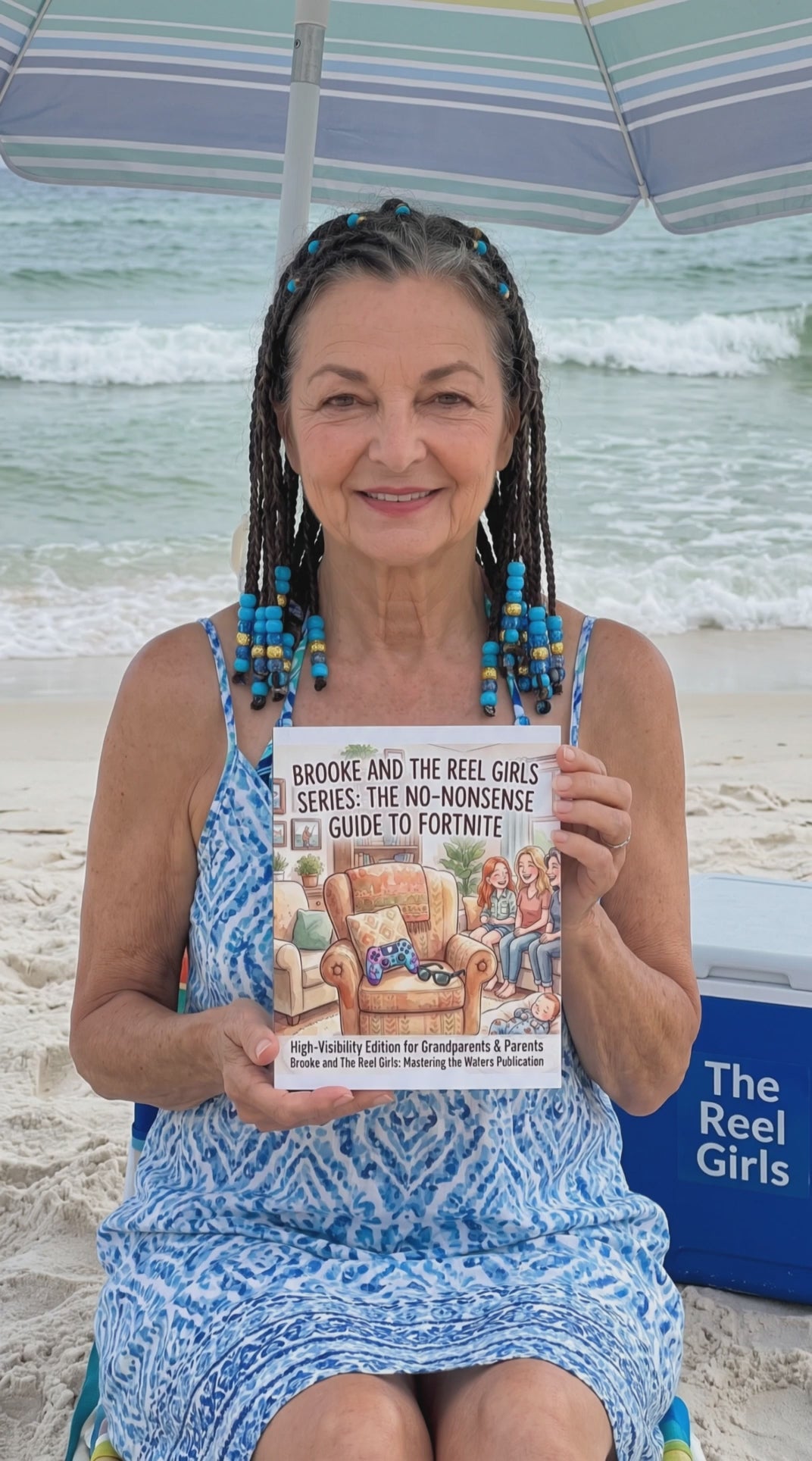 Smiling woman on a beach holding up "The No-Nonsense Guide to Fortnite" guidebook with a beach cooler beside her.
